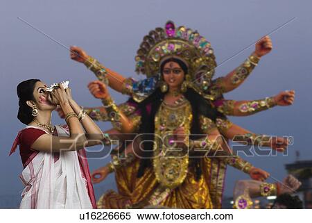 Woman blowing conch shell at Durga puja View Large Photo Image Stock Photography - Woman blowing conch shell at Durga puja. Fotosearch