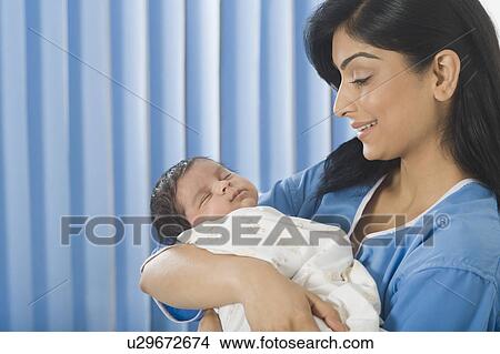 Woman carrying her baby and smiling View Large Photo Image Picture - Woman carrying her baby and smiling. Fotosearch