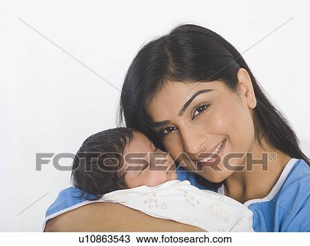 Stock Image - Woman carrying her baby and smiling. Fotosearch