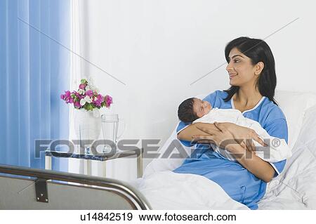 Woman carrying her baby and smiling View Large Photo Image Stock Photo - Woman carrying her baby and smiling. Fotosearch