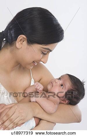 Woman carrying her baby and smiling View Large Photo Image Stock Photo - Woman carrying her baby and smiling. Fotosearch