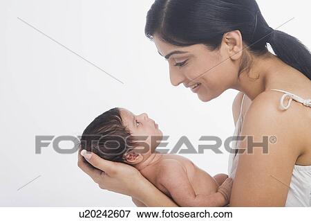 Woman carrying her baby and smiling View Large Photo Image Stock Photo - Woman carrying her baby and smiling. Fotosearch