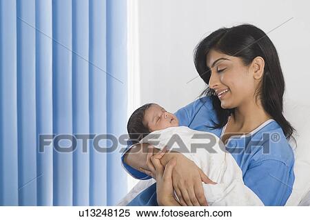 Woman carrying her baby and smiling View Large Photo Image Stock Photography - Woman carrying her baby and smiling. Fotosearch