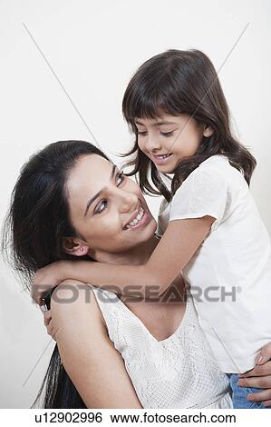 Stock Photograph - Woman carrying her daughter. Fotosearch