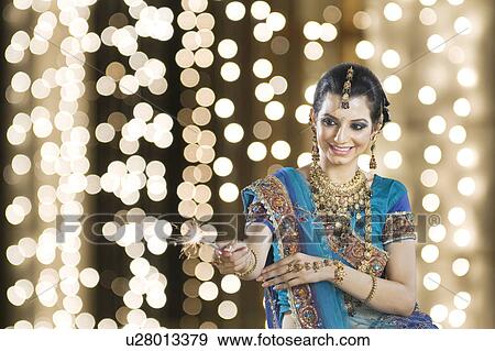 Woman celebrating Diwali festival with a sparkler View Large Photo Image Stock Photo - Woman celebrating Diwali festival with a sparkler. Fotosearch
