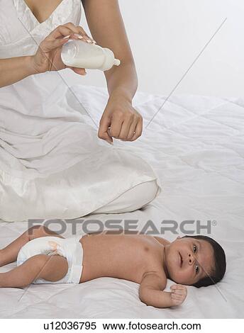 Woman checking milk before feeding her baby View Large Photo Image Stock Photography - Woman checking milk before feeding her baby. Fotosearch