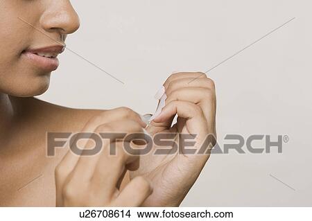 Woman clipping her fingernails View Large Photo Image Picture - Woman clipping her fingernails. Fotosearch