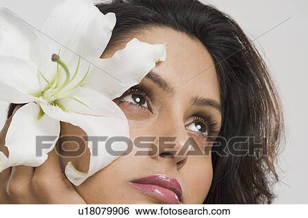 Woman day dreaming with a flower View Large Photo Image Stock Photograph - Woman day dreaming with a flower. Fotosearch