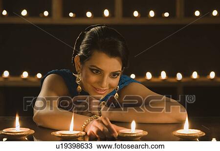 Woman decorating oil lamps in Diwali festival View Large Photo Image Stock Image - Woman decorating oil lamps in Diwali festival. Fotosearch