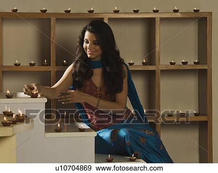 Woman decorating oil lamps in Diwali festival View Large Photo Image Stock Photo - Woman decorating oil lamps in Diwali festival. Fotosearch