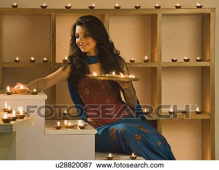 Woman decorating oil lamps in Diwali festival View Large Photo Image Stock Photo - Woman decorating oil lamps in Diwali festival. Fotosearch