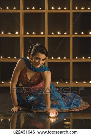Woman decorating oil lamps in Diwali festival View Large Photo Image Stock Photograph - Woman decorating oil lamps in Diwali festival. Fotosearch