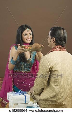 Picture - Woman doing aarti of her brother at the festival of Rakhi. Fotosearch