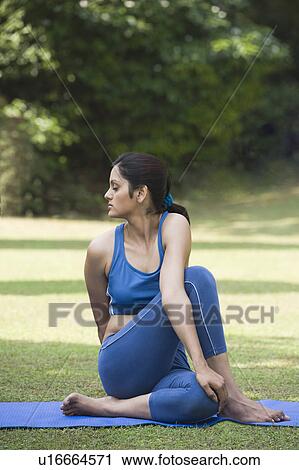 Woman doing Ardha Matsyendrasana (Half Spinal Twist) View Large Photo Image Stock Image - Woman doing Ardha Matsyendrasana (Half Spinal Twist). Fotosearch