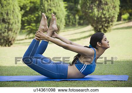 Stock Photo - Woman doing Dhanurasana (Bow Pose). Fotosearch