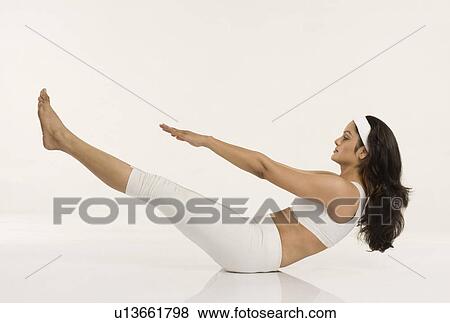 Woman doing Naukasana (Boat Pose) View Large Photo Image Stock Photo - Woman doing Naukasana (Boat Pose). Fotosearch