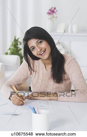 Stock Photo - Woman doing paperwork at home. Fotosearch