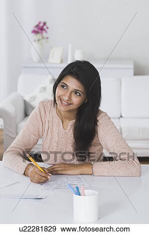 Stock Photo - Woman doing paperwork at home. Fotosearch