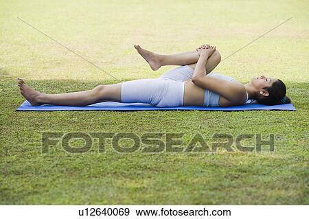 Stock Photo - Woman doing Pawanmuktasana (Wind Releasing Pose). Fotosearch
