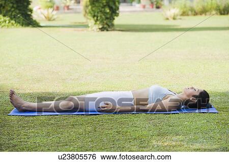 Stock Photograph - Woman doing Savasana (Corpse Pose). Fotosearch