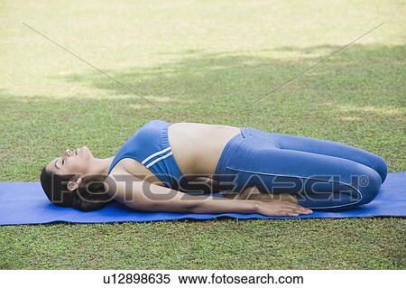 Stock Photography - Woman doing Supta Vajrasana (Reclining Adamant Pose). Fotosearch