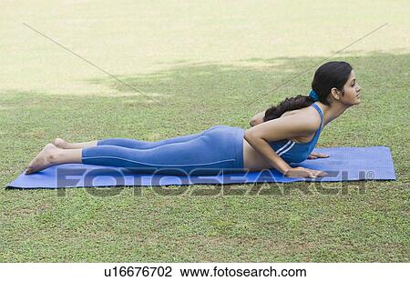 Stock Image - Woman doing Surya Namaskar (Sun Slautation). Fotosearch
