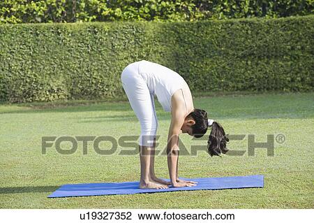 Stock Image - Woman doing Surya Namaskar (Sun Slautation). Fotosearch