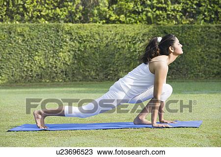 Stock Image - Woman doing Surya Namaskar (Sun Slautation). Fotosearch