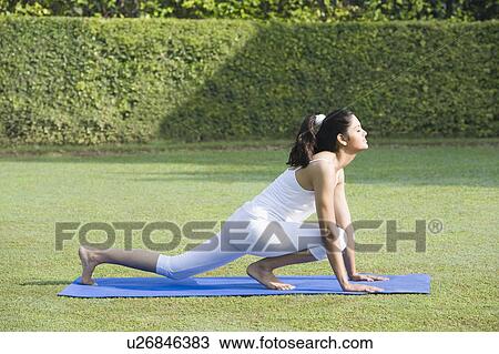 Stock Image - Woman doing Surya Namaskar (Sun Slautation). Fotosearch