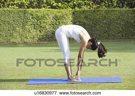 Stock Photo - Woman doing Surya Namaskar (Sun Slautation). Fotosearch