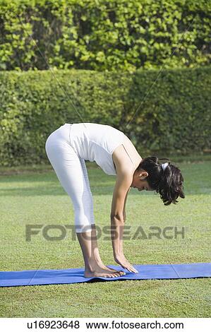 Stock Photo - Woman doing Surya Namaskar (Sun Slautation). Fotosearch