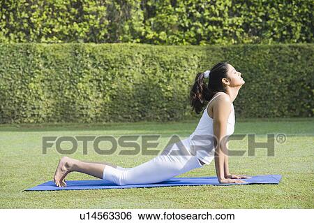 Stock Photograph - Woman doing Surya Namaskar (Sun Slautation). Fotosearch