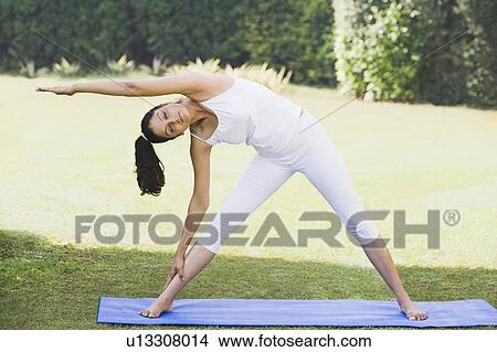 Picture - Woman doing Trikonasana (Triangle Position). Fotosearch