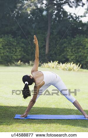 Woman doing Trikonasana (Triangle Position) View Large Photo Image Stock Photo - Woman doing Trikonasana (Triangle Position). Fotosearch