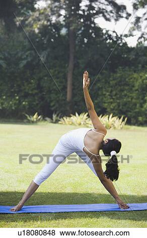 Stock Photo - Woman doing Trikonasana (Triangle Position). Fotosearch