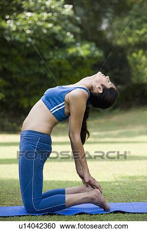 Stock Image - Woman doing Ustrasana (Camel Pose). Fotosearch