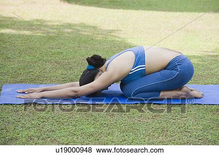 Stock Photo - Woman doing Utthita Balasana (Extended Child'S Pose). Fotosearch