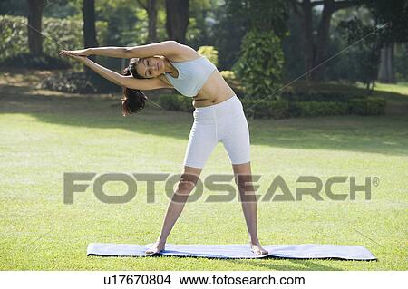 Picture - Woman exercising in a park. Fotosearch
