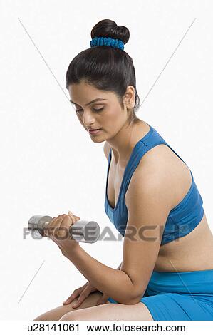 Woman exercising with a dumbbell View Large Photo Image Stock Image - Woman exercising with a dumbbell. Fotosearch