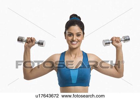 Stock Image - Woman exercising with dumbbells. Fotosearch