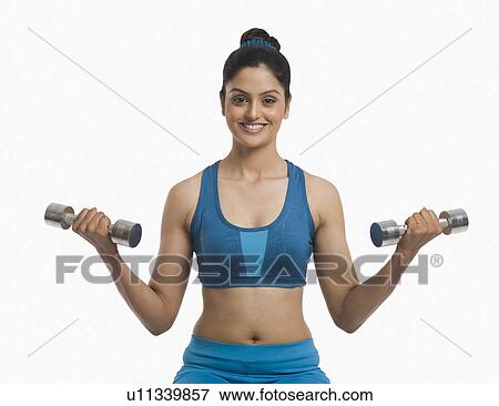 Woman exercising with dumbbells View Large Photo Image Stock Photo - Woman exercising with dumbbells. Fotosearch