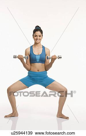 Woman exercising with dumbbells View Large Photo Image Stock Photo - Woman exercising with dumbbells. Fotosearch