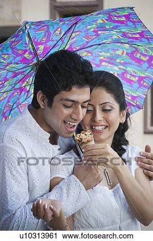 Woman feeding an ice cream to a man View Large Photo Image Stock Image - Woman feeding an ice cream to a man. Fotosearch
