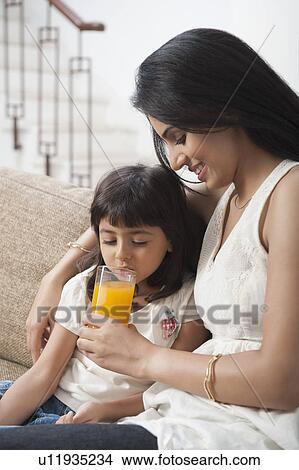 Woman feeding juice to her daughter View Large Photo Image Picture - Woman feeding juice to her daughter. Fotosearch