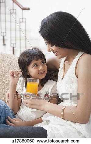 Woman feeding juice to her daughter View Large Photo Image Stock Image - Woman feeding juice to her daughter. Fotosearch