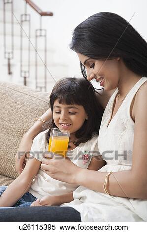 Woman feeding juice to her daughter View Large Photo Image Stock Photography - Woman feeding juice to her daughter. Fotosearch
