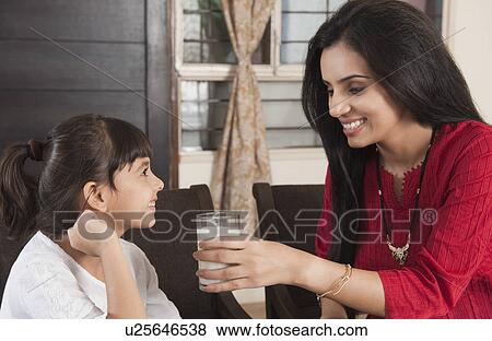 Woman feeding milk to her daughter View Large Photo Image Stock Photo - Woman feeding milk to her daughter. Fotosearch