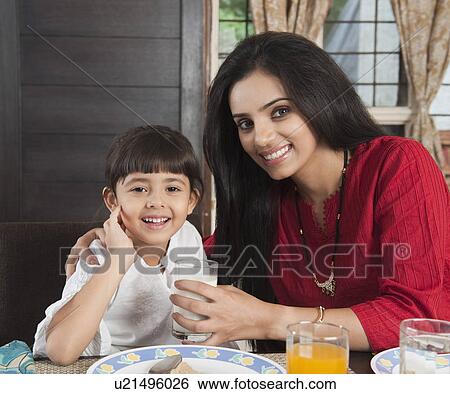 Woman feeding milk to her daughter View Large Photo Image Stock Photograph - Woman feeding milk to her daughter. Fotosearch