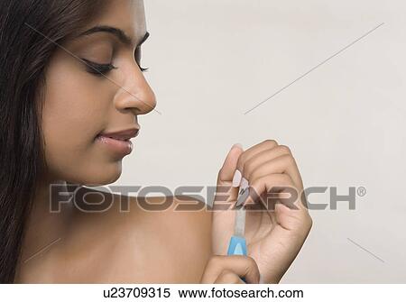 Stock Photography - Woman filing her fingernails. Fotosearch