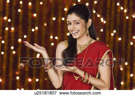 Woman gesturing in front of Diwali decoration View Large Photo Image Stock Photo - Woman gesturing in front of Diwali decoration. Fotosearch